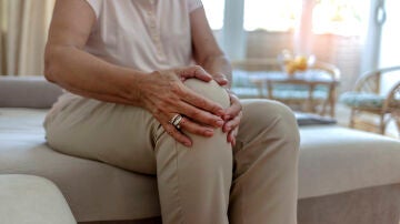 Mujer con dolor en la rodilla Mujer con dolor en la rodilla