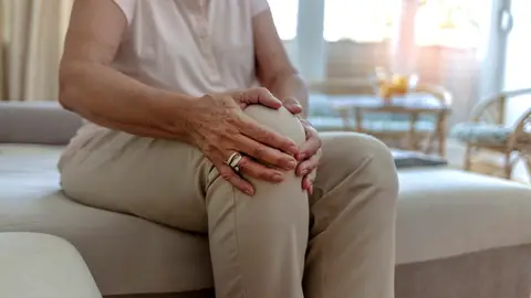 Mujer con dolor en la rodilla Mujer con dolor en la rodilla