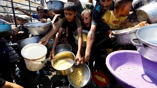 Niños palestinos recogen comida en los puntos de ayuda humanitaria Niños palestinos recogen comida en los puntos de ayuda humanitaria