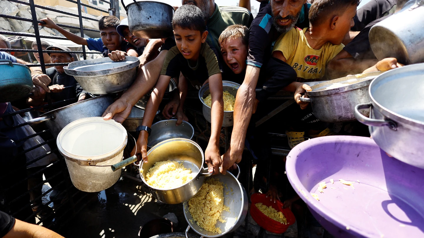 Niños palestinos recogen comida en los puntos de ayuda humanitaria Niños palestinos recogen comida en los puntos de ayuda humanitaria