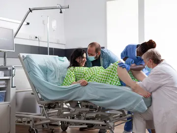 Una mujer en el momento del parto en posición de litotomía. Una mujer en el momento del parto en posición de litotomía.