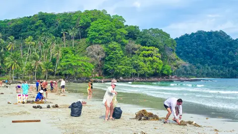 Turismo solidario con gente limpiando una playa Turismo solidario con gente limpiando una playa