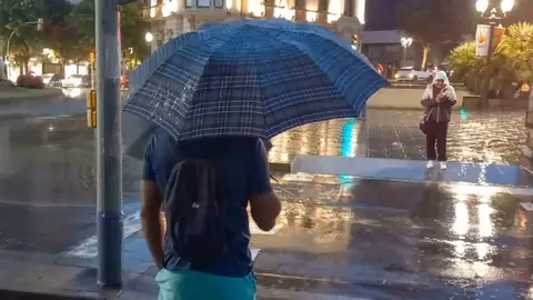 Varias personas bajo la lluvia en Tarragona, este lunes. Varias personas bajo la lluvia en Tarragona, este lunes.