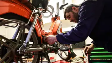 Un mecánico da los últimos toques para convertir una moto de combustión en una moto eléctrica en Francia. Un mecánico da los últimos toques para convertir una moto de combustión en una moto eléctrica en Francia.