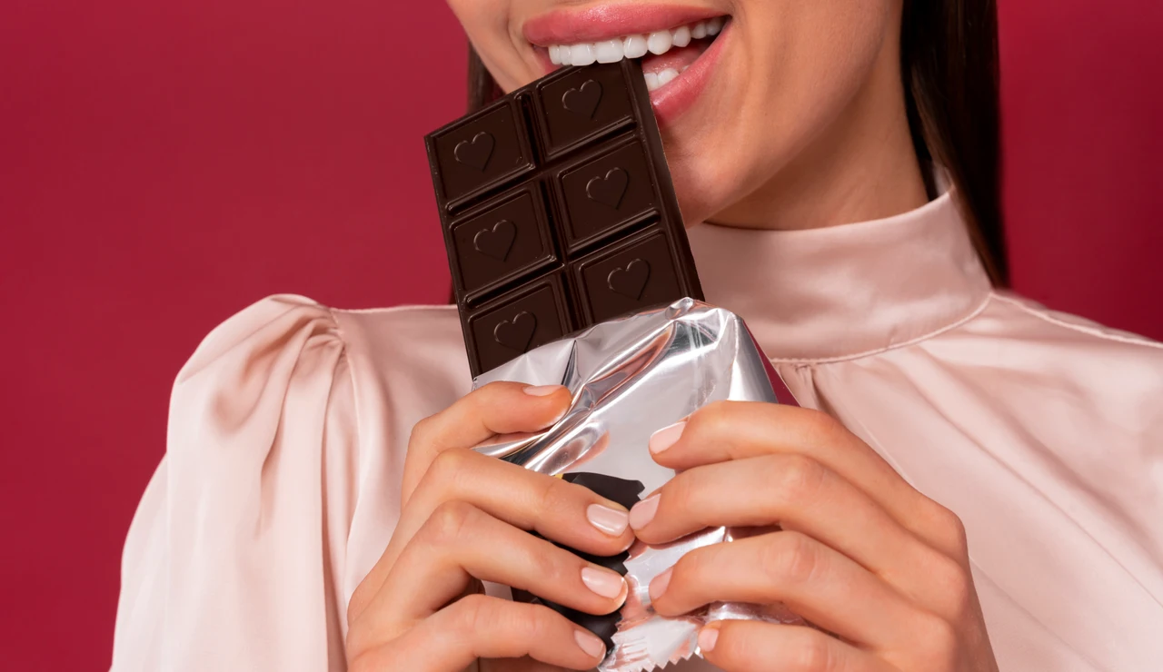 Una mujer comiendo una tableta de chocolate