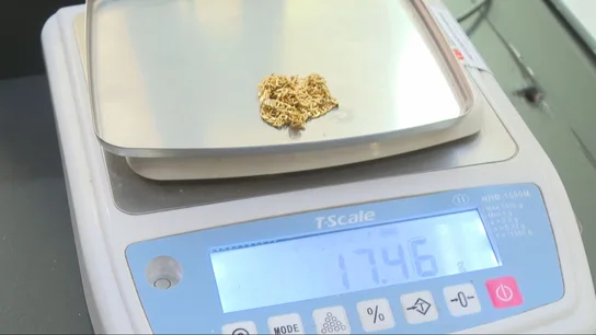 Una cadena de oro siendo pesada para su venta. Una cadena de oro siendo pesada para su venta.