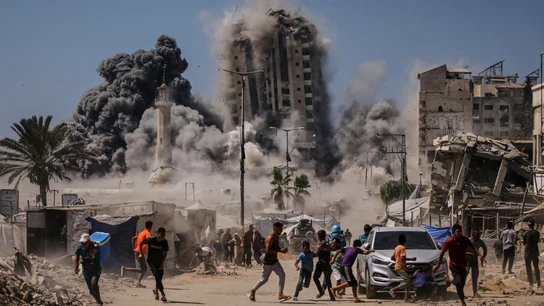 Ciudadanos gazatíes huyen ante el derrumbe de un edificio residencial bombardeado por el Ejército de Israel Ciudadanos gazatíes huyen ante el derrumbe de un edificio residencial bombardeado por el Ejército de Israel