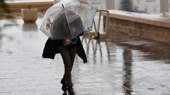 Una persona se resguarda con un paraguas de la lluvia, en una fotograf&iacute;a de archivo. 