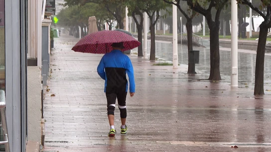 Una persona caminando bajo la lluvia en Valencia Una persona caminando bajo la lluvia en Valencia