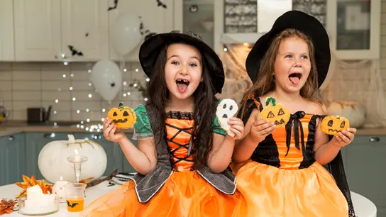 Dos niñas se divierten con disfraces y recetas de Halloween. Dos niñas se divierten con disfraces y recetas de Halloween.