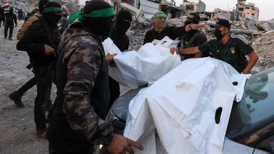 Militantes palestinos de Hamás transportan cuerpos de israelíes secuestrados. Militantes palestinos de Hamás transportan cuerpos de israelíes secuestrados.