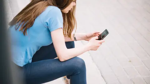 Una adolecente usando su móvil. Una adolecente usando su móvil.