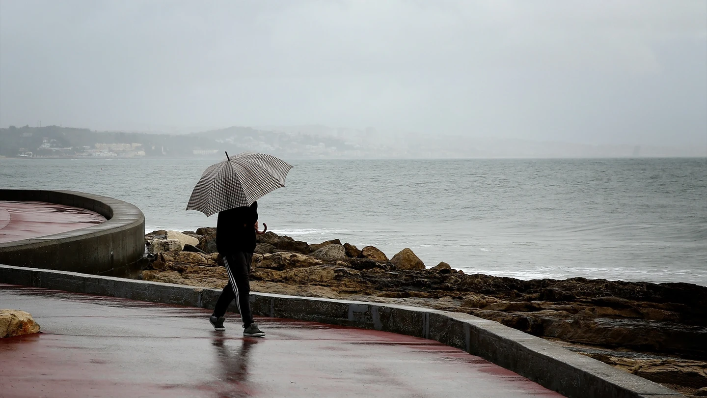 Una persona con un paraguas bajo la lluvia en Lisboa, Portugal Una persona con un paraguas bajo la lluvia en Lisboa, Portugal