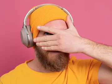 Hombre escuchando música y tapándose los ojos Hombre escuchando música y tapándose los ojos