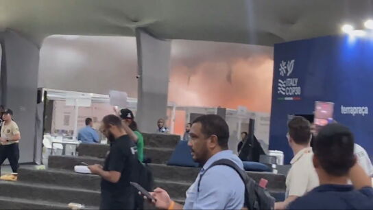 Im&aacute;genes del pabell&oacute;n de negociaciones de la COP30 con el incendio al fondo