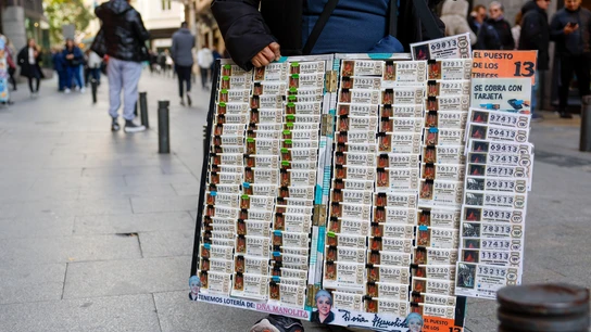 Un vendedor de Lotería de Navidad, junto a la cola de 'Doña Manolita' en Madrid Un vendedor de Lotería de Navidad, junto a la cola de 'Doña Manolita' en Madrid