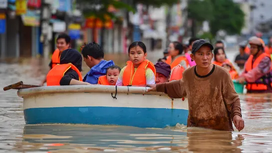 Personas se abren paso entre las aguas de la inundación en Nha Trang, provincia de Khanh Hoa, Vietnam. Personas se abren paso entre las aguas de la inundación en Nha Trang, provincia de Khanh Hoa, Vietnam.
