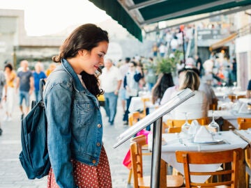Chica mirando el men&uacute; de un restaurante