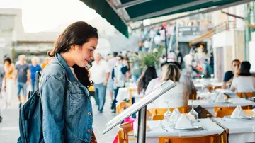 Chica mirando el menú de un restaurante Chica mirando el menú de un restaurante