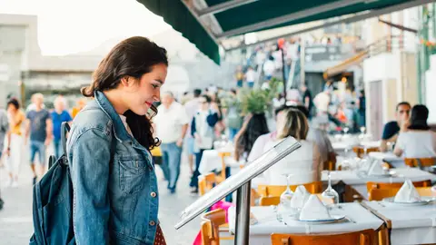 Chica mirando el menú de un restaurante Chica mirando el menú de un restaurante