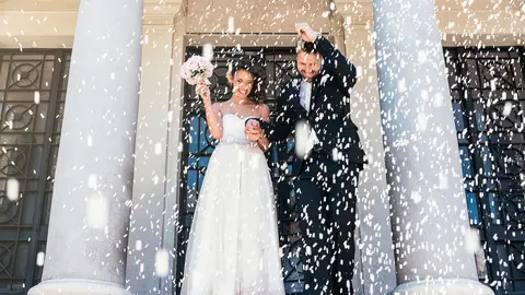 Una pareja de novios bañada en arroz tras casarse Una pareja de novios bañada en arroz tras casarse