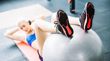 Una mujer realiza ejercicios con la fitball Una mujer realiza ejercicios con la fitball