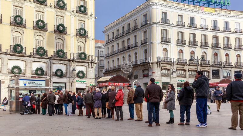 Fila de personas esperando para comprar Loter&iacute;a en la Puerta del Sol de Madrid