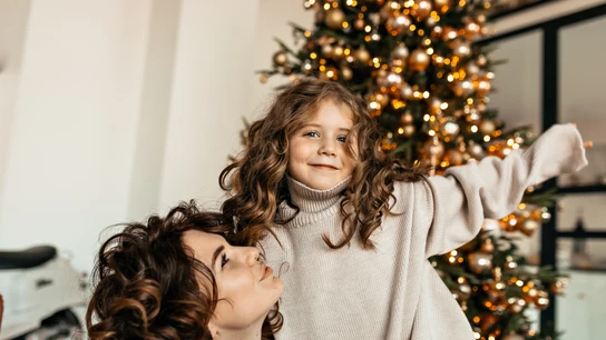 Una mujer con su hija en una escena navideña Una mujer con su hija en una escena navideña