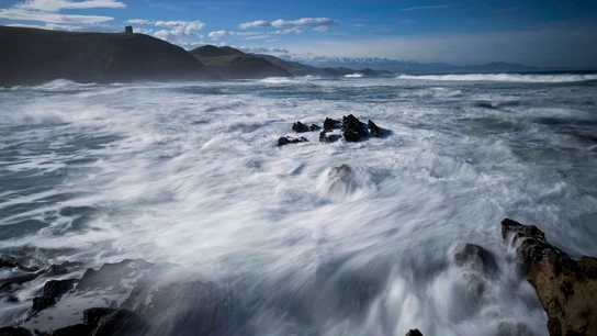 Oleaje, este jueves, en la playa de la localidad cántabra de Tagle con los Picos de Europa al fondo Oleaje, este jueves, en la playa de la localidad cántabra de Tagle con los Picos de Europa al fondo