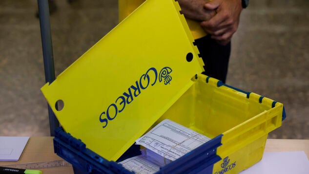 Un empleado de Correos entrega el voto por correo a una mesa electoral, en una imagen de archivo. 