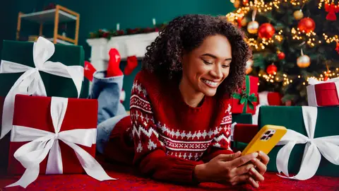Una mujer con su teléfono móvil en Navidad Una mujer con su teléfono móvil en Navidad