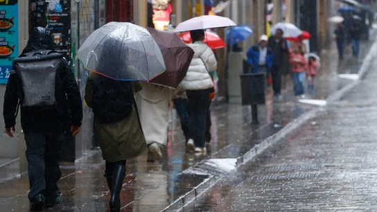 Varias personas se protegen de la lluvia en el centro de Barcelona Varias personas se protegen de la lluvia en el centro de Barcelona