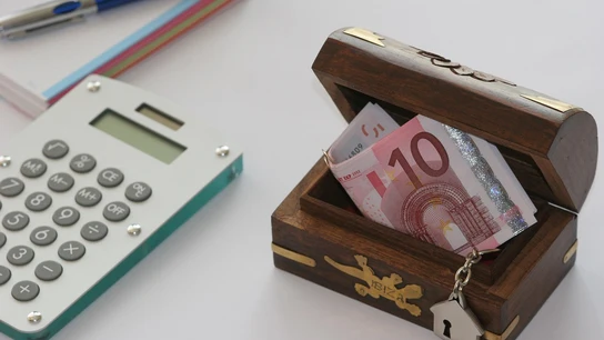 Imagen de un cofre con dinero y una calculadora Imagen de un cofre con dinero y una calculadora