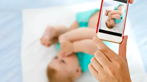 Padre fotografiando a su bebé Padre fotografiando a su bebé