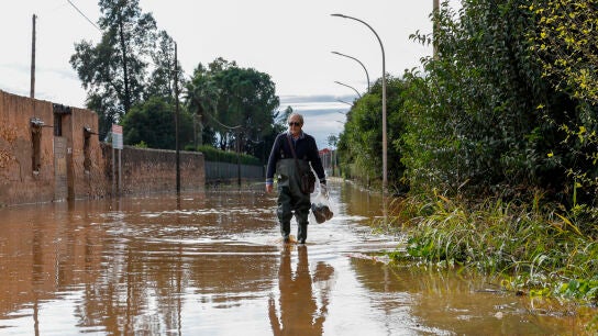 Un vecino de Carcaixent camina por las calles inundadas del municipio valenciano.