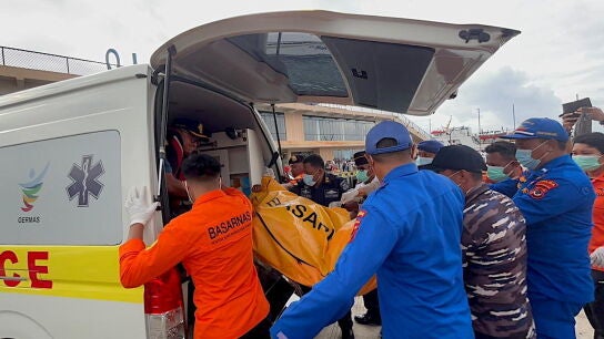 Rescatistas transportando el cuerpo de una v&iacute;ctima de un accidente de barco tur&iacute;stico a una ambulancia en el puerto de Labuan Bajo