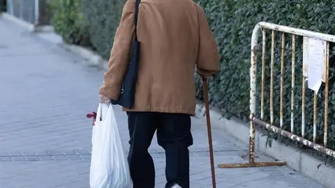 Una persona mayor camina con ayuda de un bastón. Una persona mayor camina con ayuda de un bastón.