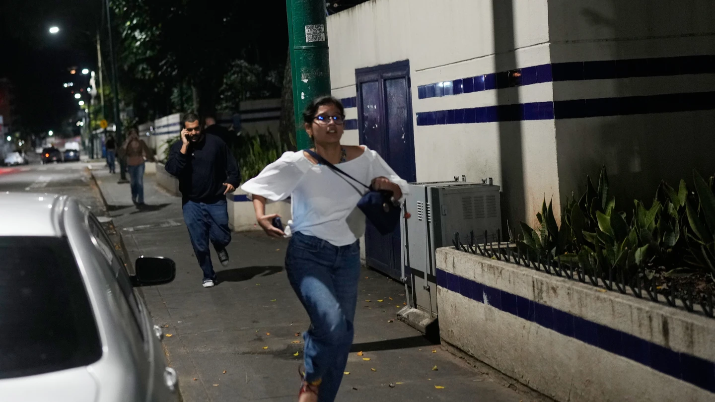 Peatones corren tras escuchar explosiones y aviones volando a baja altura en Caracas, Venezuela, la madrugada de este sábado. Peatones corren tras escuchar explosiones y aviones volando a baja altura en Caracas, Venezuela, la madrugada de este sábado.