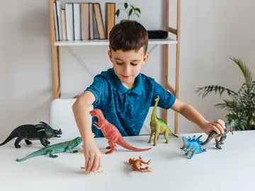 Niño jugando con dinosaurios Niño jugando con dinosaurios