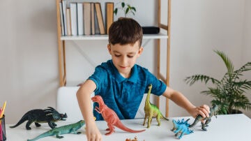 Ni&ntilde;o jugando con dinosaurios