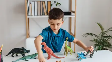 Niño jugando con dinosaurios Niño jugando con dinosaurios