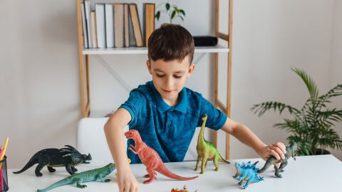 Ni&ntilde;o jugando con dinosaurios