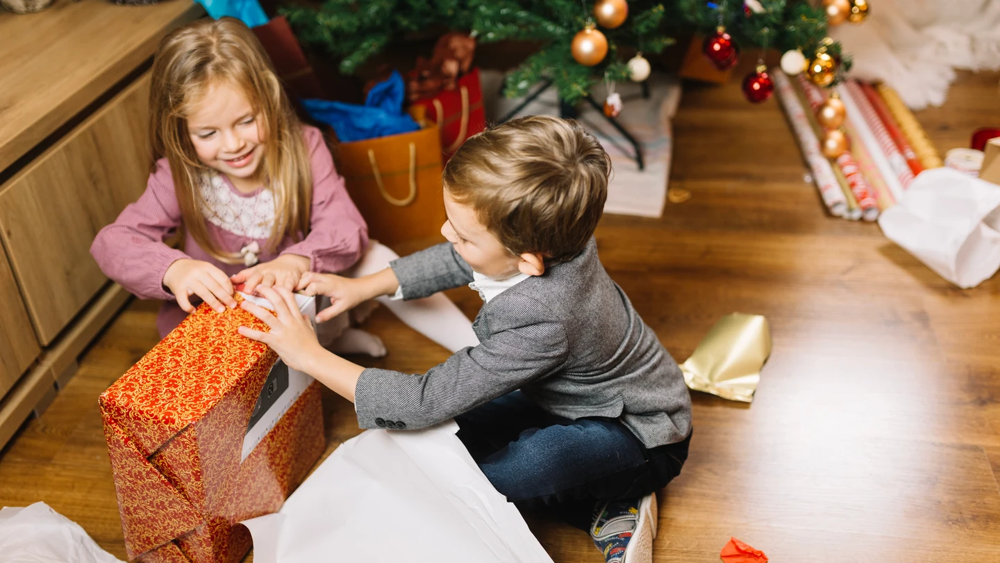 Unos niños abriendo regalos Unos niños abriendo regalos