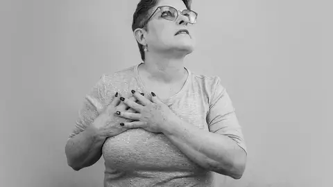 Mujer tocándose un pecho Mujer tocándose un pecho