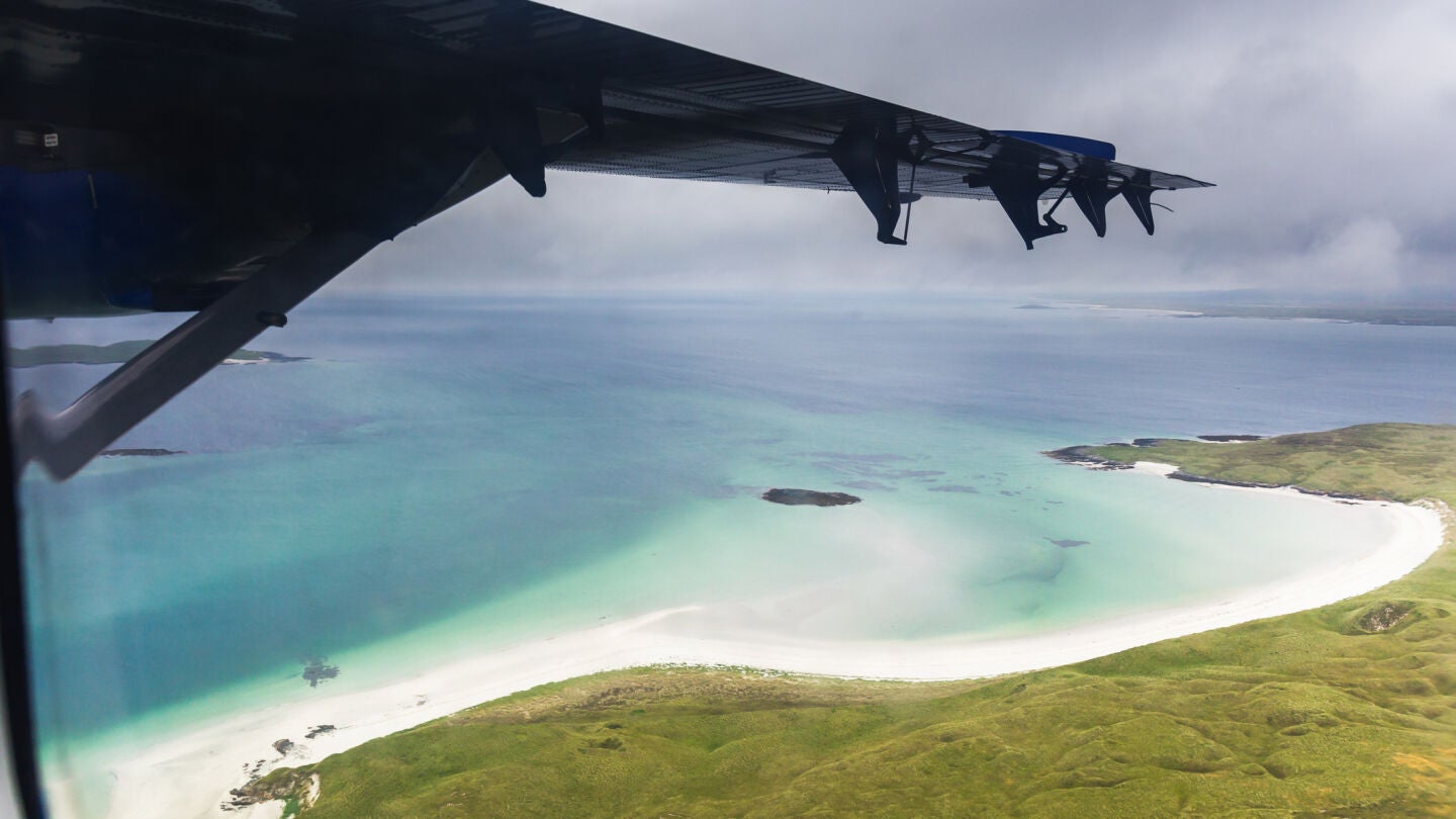 Un avi&oacute;n sobrevolando una isla de Escocia