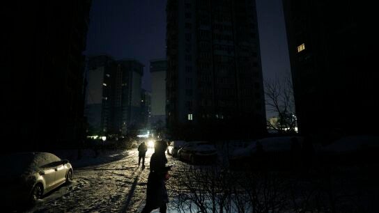 Una mujer camina en la oscuridad por los cortes de electricidad tras los ataques rusos contra la infraestructura energ&eacute;tica en Kyiv.