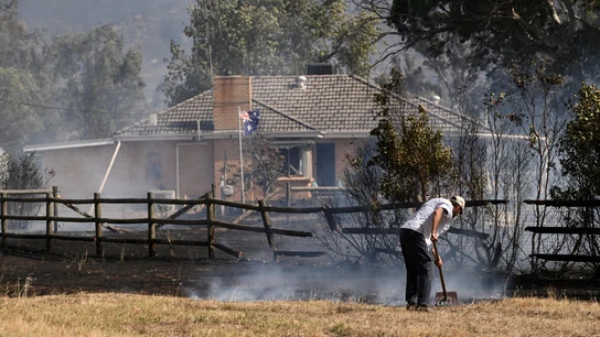 Un hombre cerca de una propiedad rodeada de tierra quemada en Longwood, Victoria, Australia. Un hombre cerca de una propiedad rodeada de tierra quemada en Longwood, Victoria, Australia.