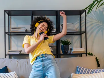 Mujer joven escuchando y cantando una canción Mujer joven escuchando y cantando una canción