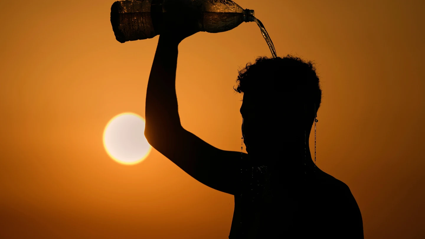 Una persona se refresca echándose agua por encima debido al calor Una persona se refresca echándose agua por encima debido al calor
