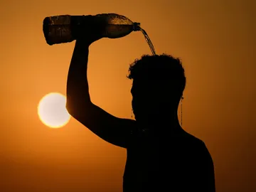 Una persona se refresca echándose agua por encima debido al calor Una persona se refresca echándose agua por encima debido al calor